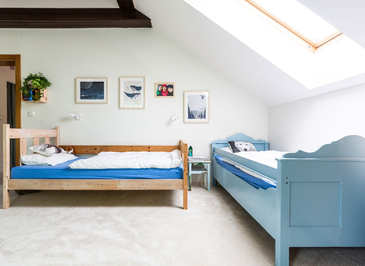 dětský pokoj v podkroví ve venkovském stylu s modrou dřevěnou postelí a postelí v přírodné barvě dřeva
