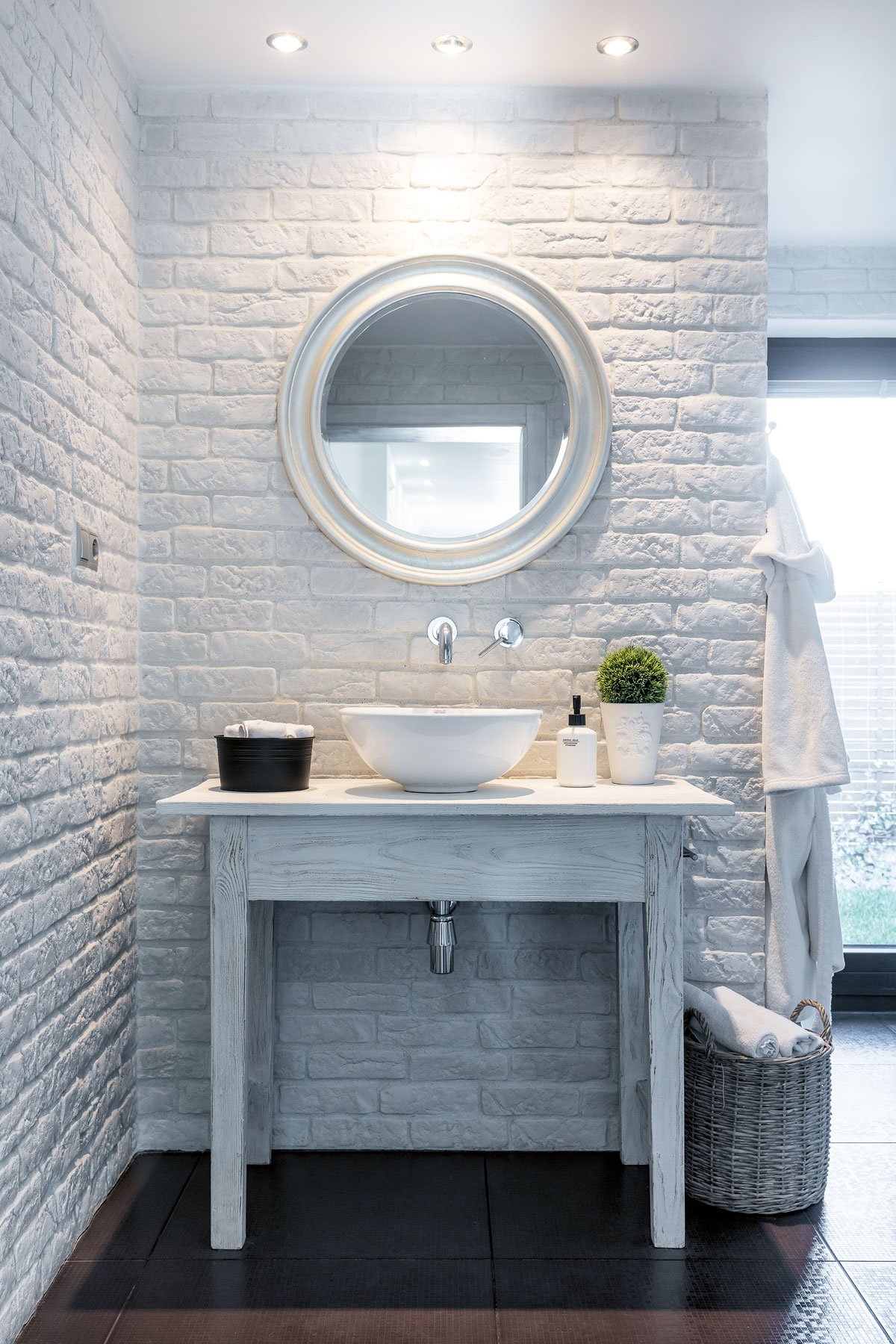 Detail koupelnové cihlové stěny se stolkem, umývadlem a zrcadlem