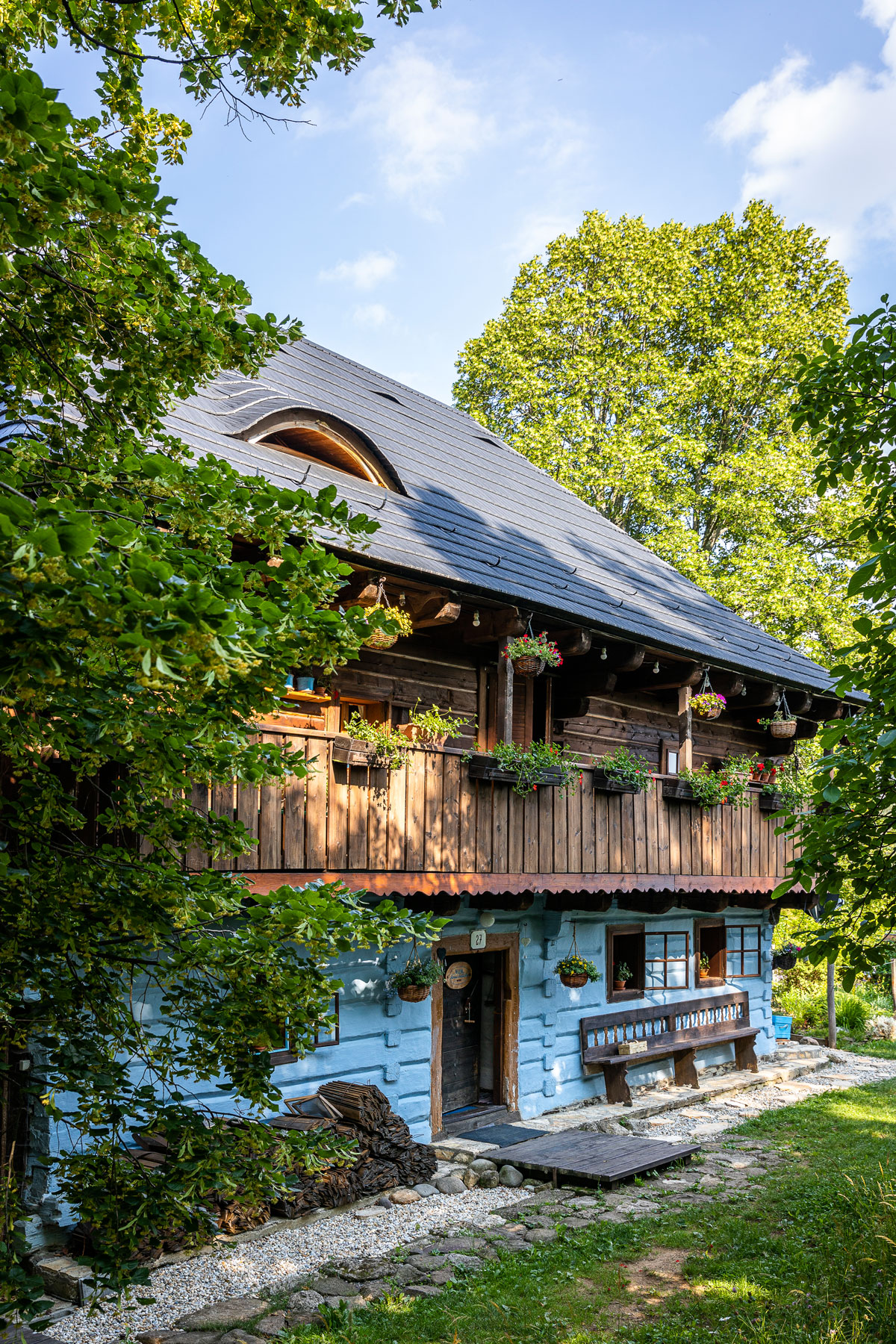 Modrá chaloupka s dřevěnou verandou