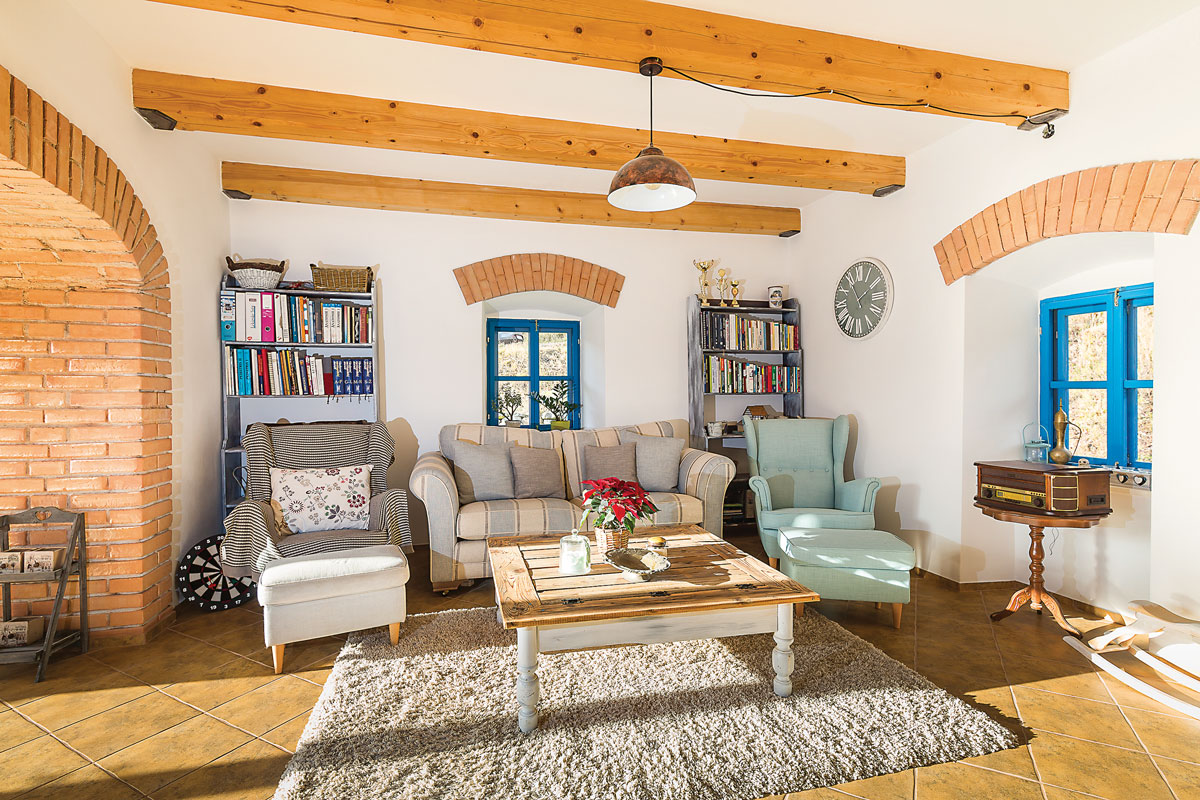 obývací pokoj ve venkovském stylu s dřevěnými trámi na zdi a nadokenními oblouky z cihel