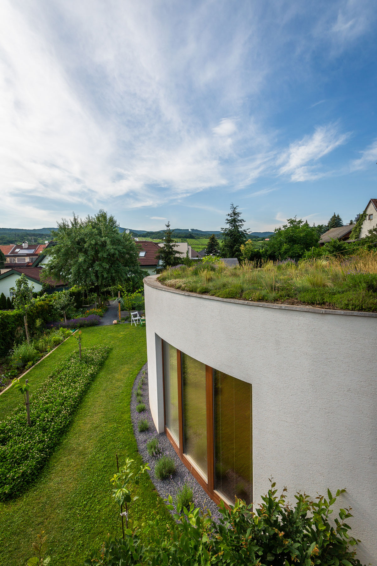 rodinný dům se zelenou střechou a zahradou ve svahu