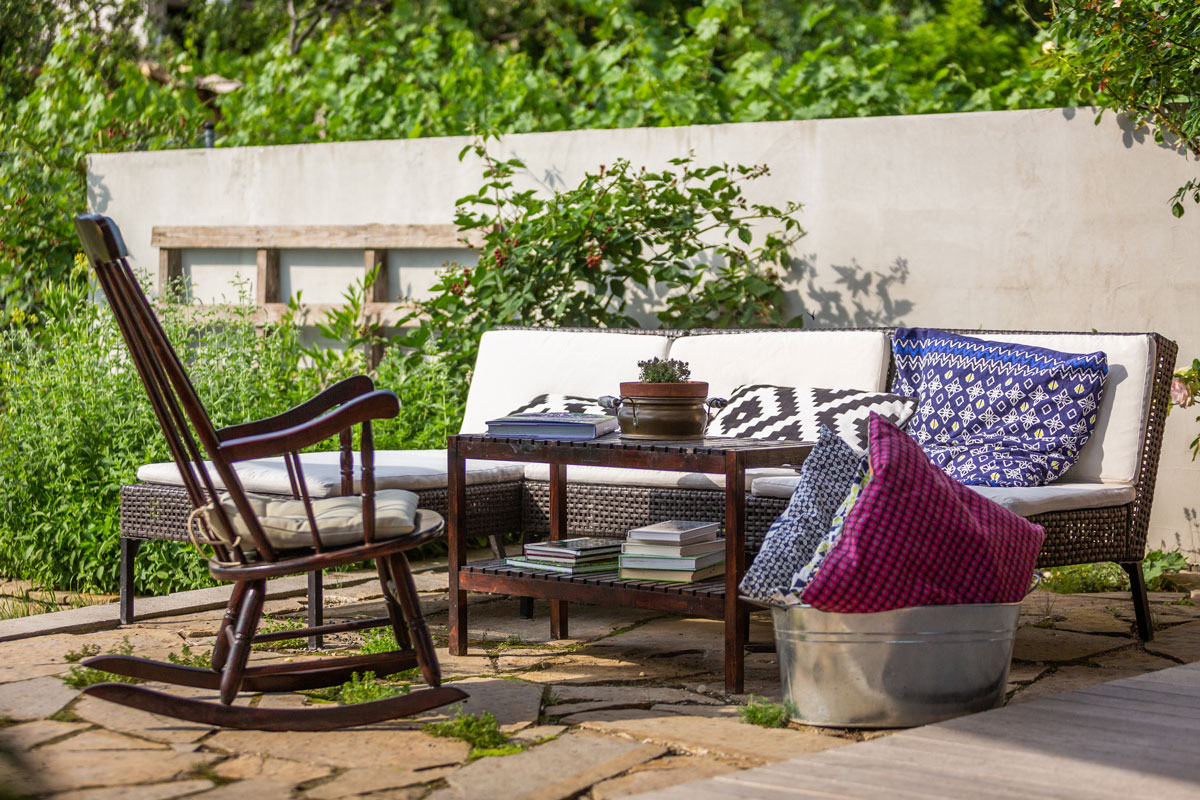 houpací židle, stolek a pohovka na zahradní kamenné terase
