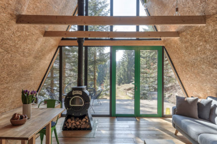 interiér klasické horské chaty ze střechou z OSB desek a prosklenou stěnou s výhledem do krajiny