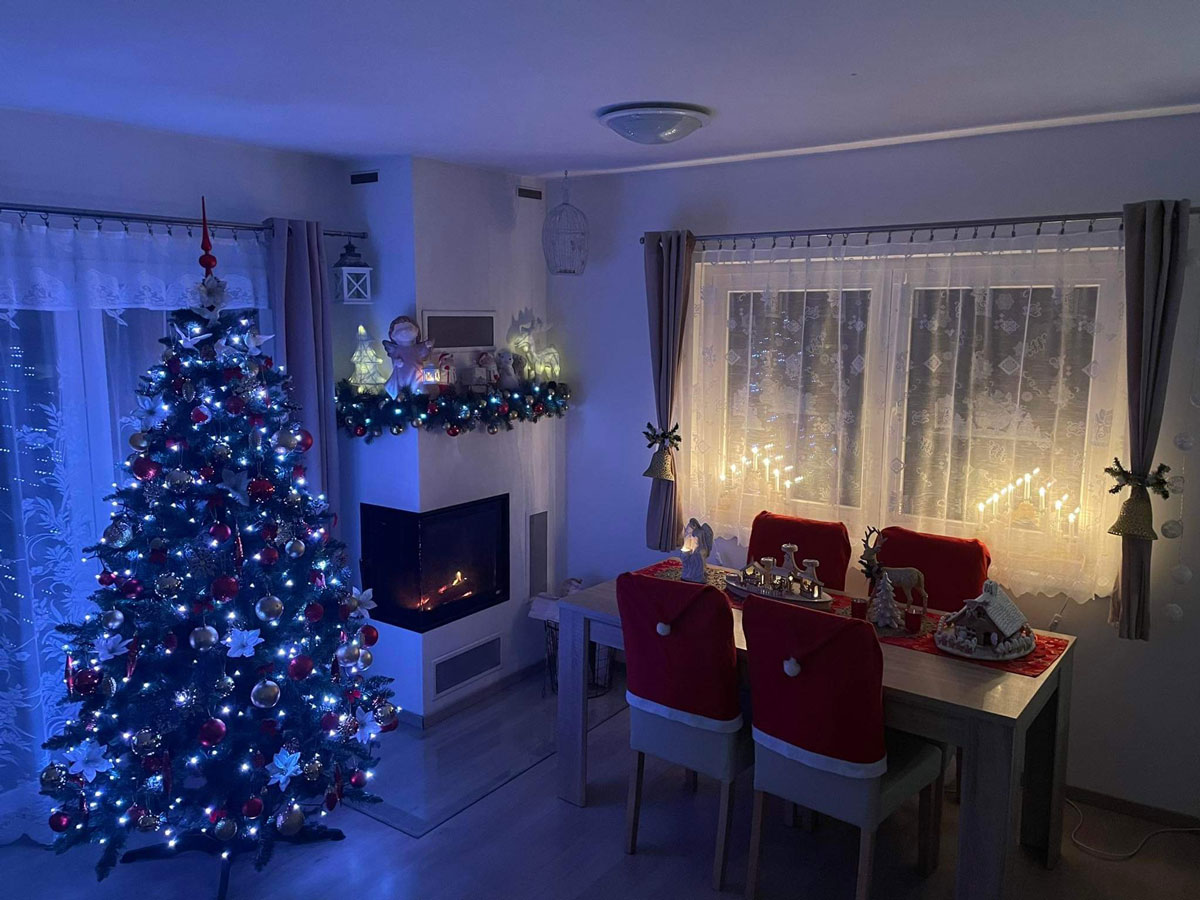 interiér s vánočním stromečkem, girlandou na krbu a vánočním jídelním stolem