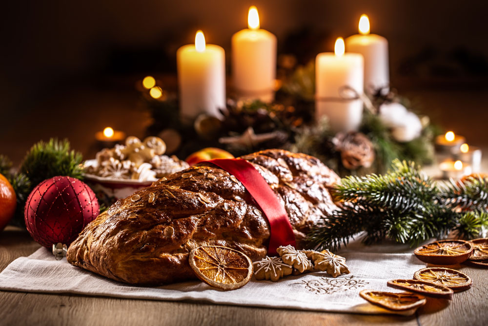 tradiční vánočka a adventní věnec s jehličím na stole
