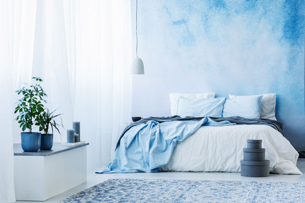 ložnice s modrou akvarelovou stěnou