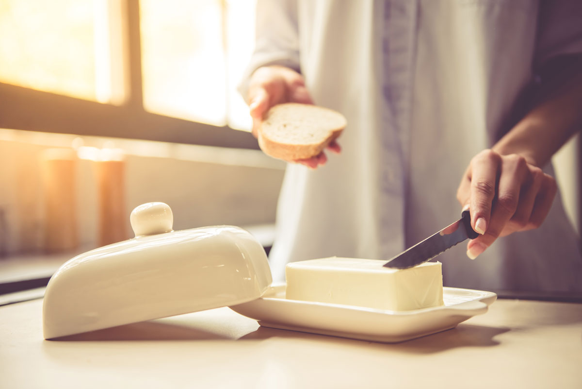 žena natírá chléb máslem