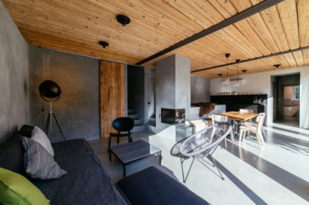 Moderní otevřený prostor obývacího pokoje, jídelny a kuchyně s pecí a krbem