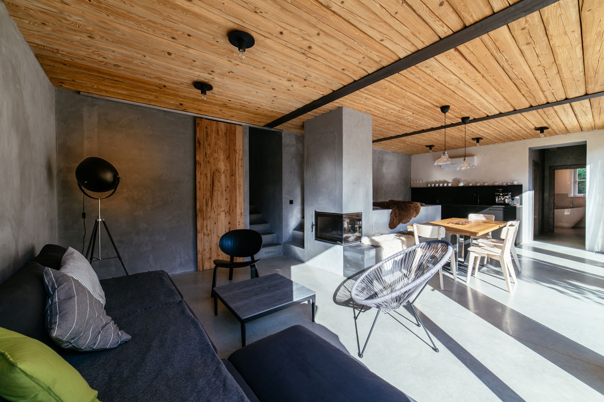 Moderní otevřený prostor obývacího pokoje, jídelny a kuchyně s pecí a krbem