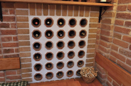 Detail boxu na lahve s vínem zhotovených z drenážních trubek a ze stavby zbylých šamotových cihel