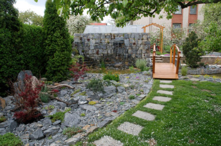 zahrada v japonském stylu, s kamennou zahradou a jezírkem se zdí, která ukrývá zahradní stavbu skleníku