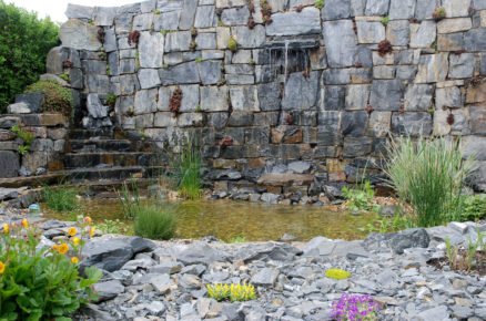 kamenná zeď v zahradě s vodopádem, která je součástí jezírka