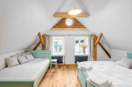 podkrovní ložnice ve venkovském stylu s mentolově zelenými postelami