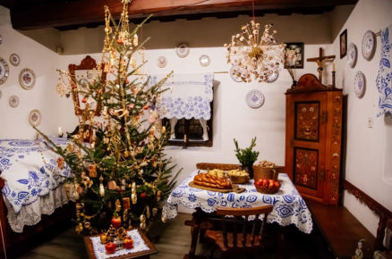 Venkovský interiér s přírodním vánočním stromkem a polazem