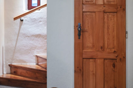 chodba na chalupě s dřevěnými dveřmi a schodištěm