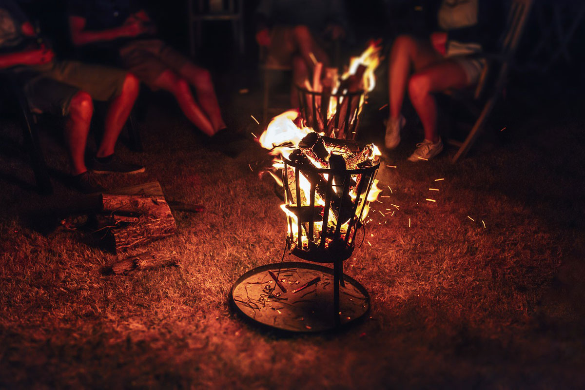Lidé sedící v noci u ohniště