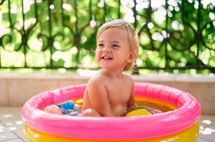 Dítě sedí v barevném dětském bazénu