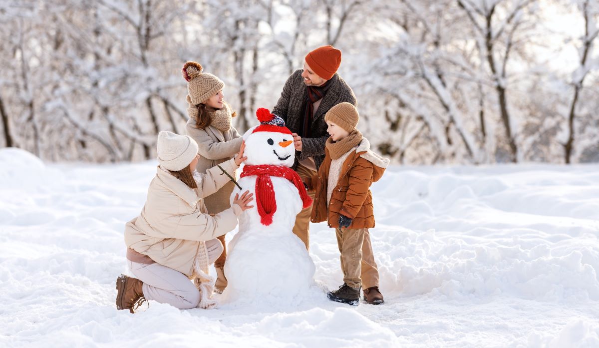 Rodina staví sněhuláka