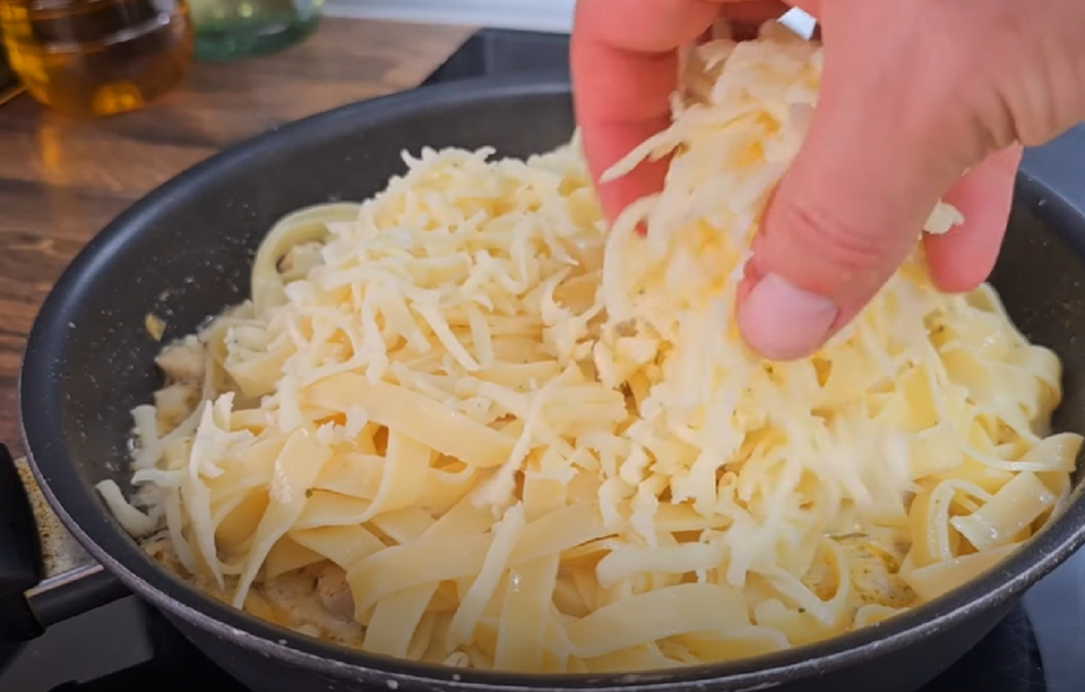 Potom přidáme uvařené těstoviny, 150g nastrouhané mozzarelly a promícháme