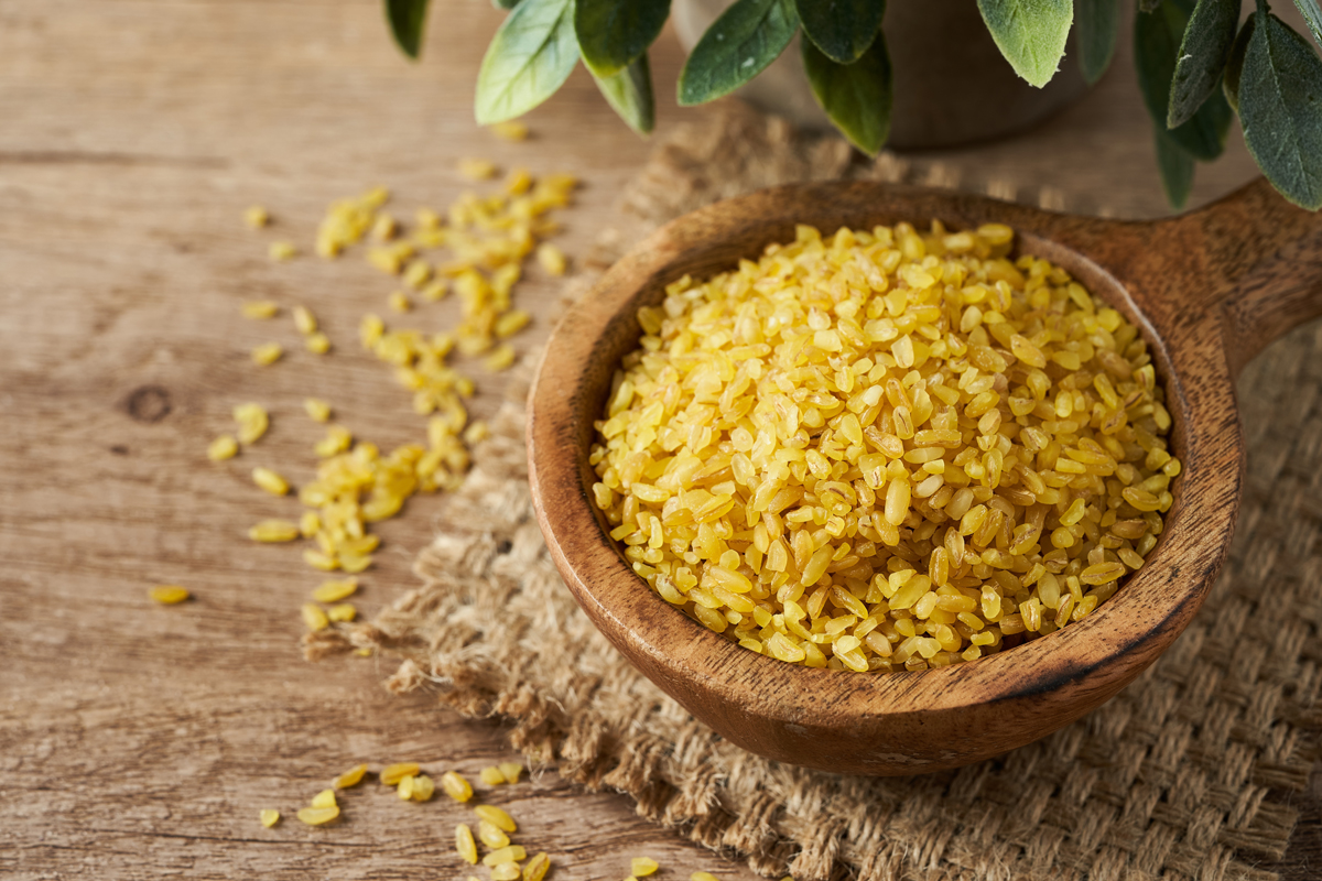 Bulgur v dřevěné misce na stole. 