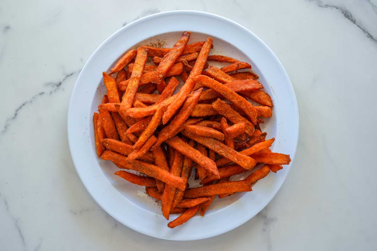 batatove hranolky Křupavé domácí batátové hranolky servírované na bílém talíři.