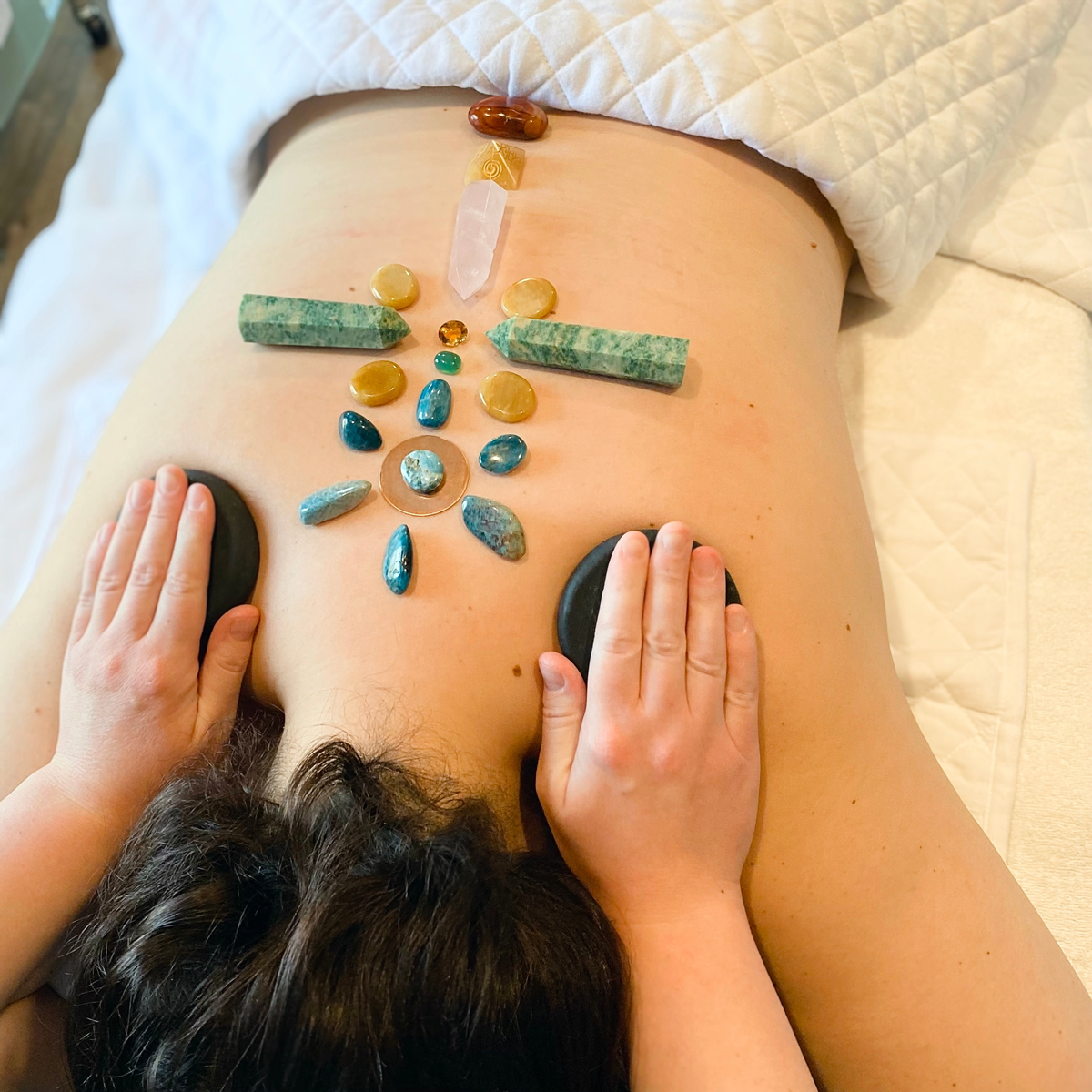 lecive krystaly Terapeut pokládá barevné krystaly a kameny na záda člověka při alternativní léčebné terapii.
