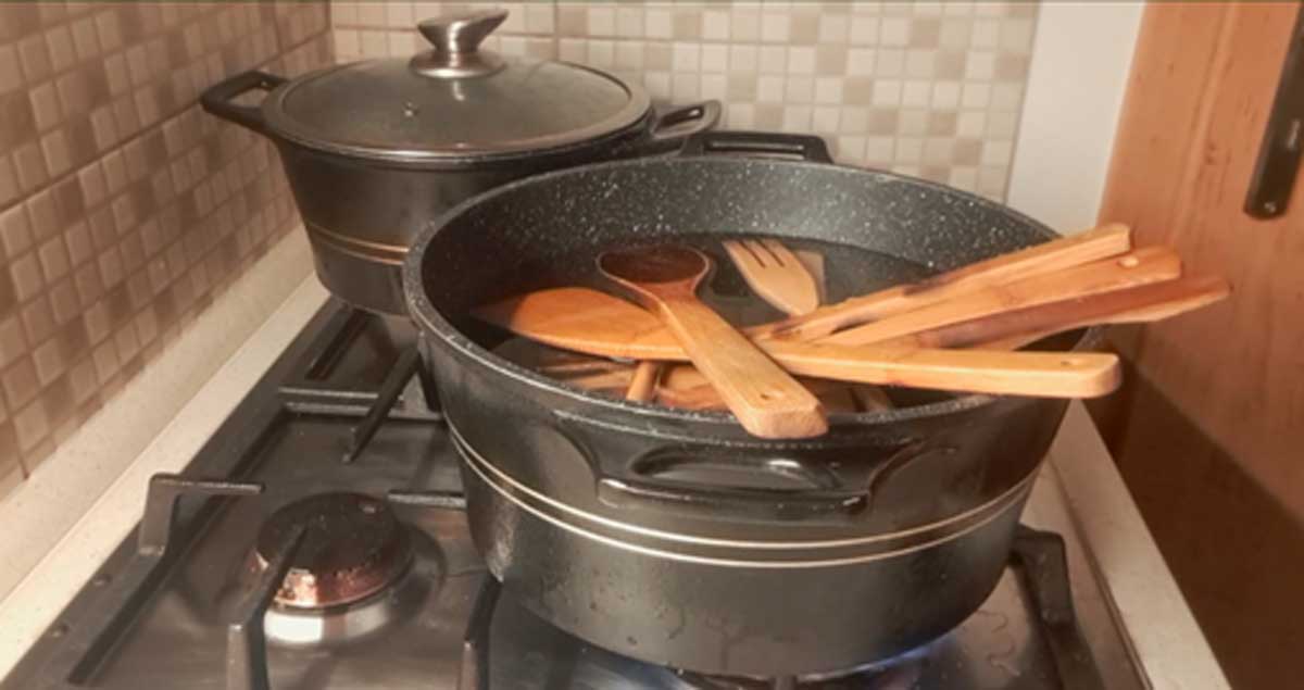 varecky v hrnci Dřevěné vařečky ponořené ve vroucí vodě při čištění starých kuchyňských nástrojů