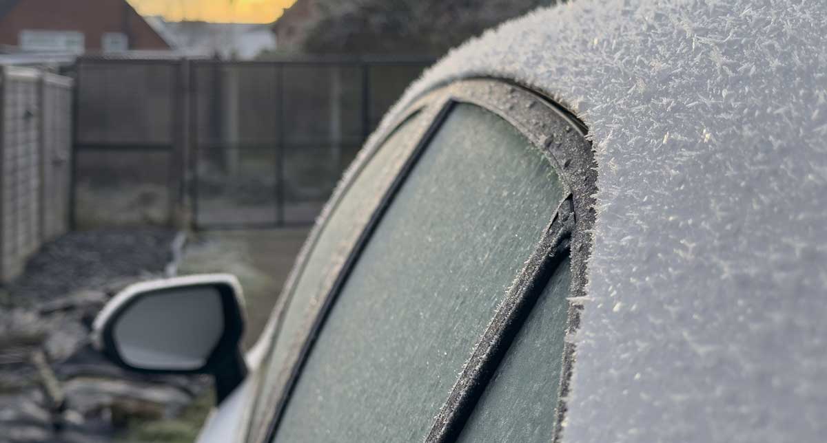 Auto pokryté silnou vrstvou námrazy a jinovatky po chladné noci.