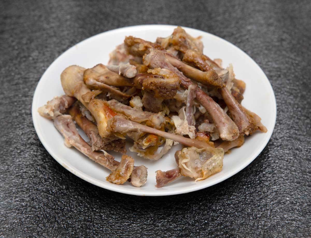 zbytky masa talíř s kostmi a zbytky masa které do kompostu v zimě nepatří