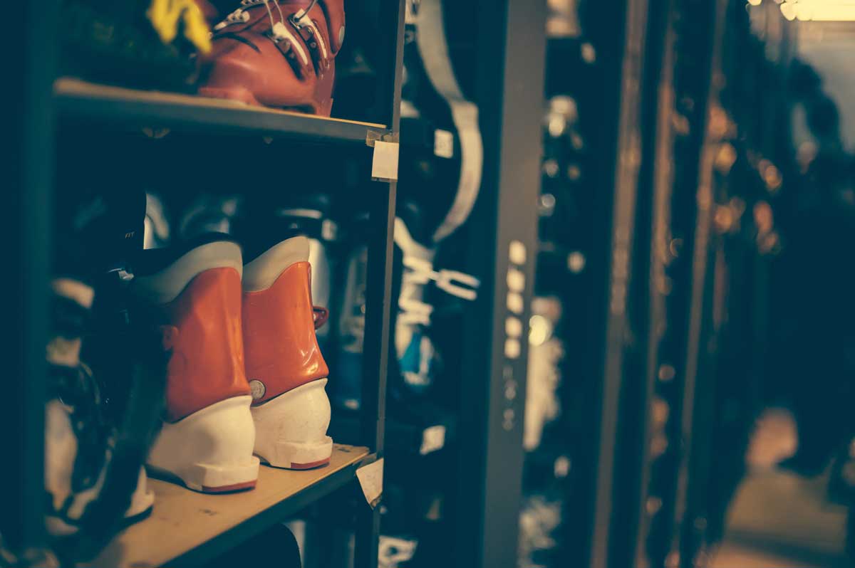 Lyžařské boty uložené ve stojanech v půjčovně lyžařského vybavení