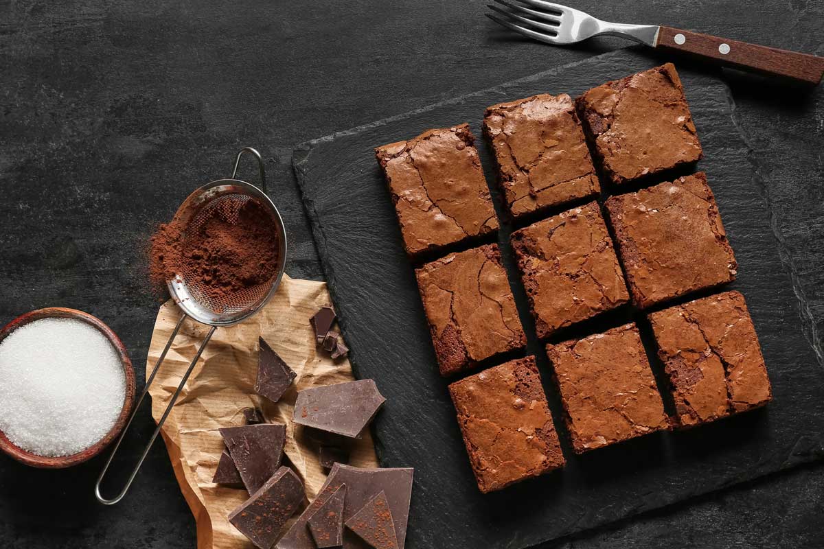 Brownies bez cukru z černých fazolí nakrájené na čtverce na tmavé podložce