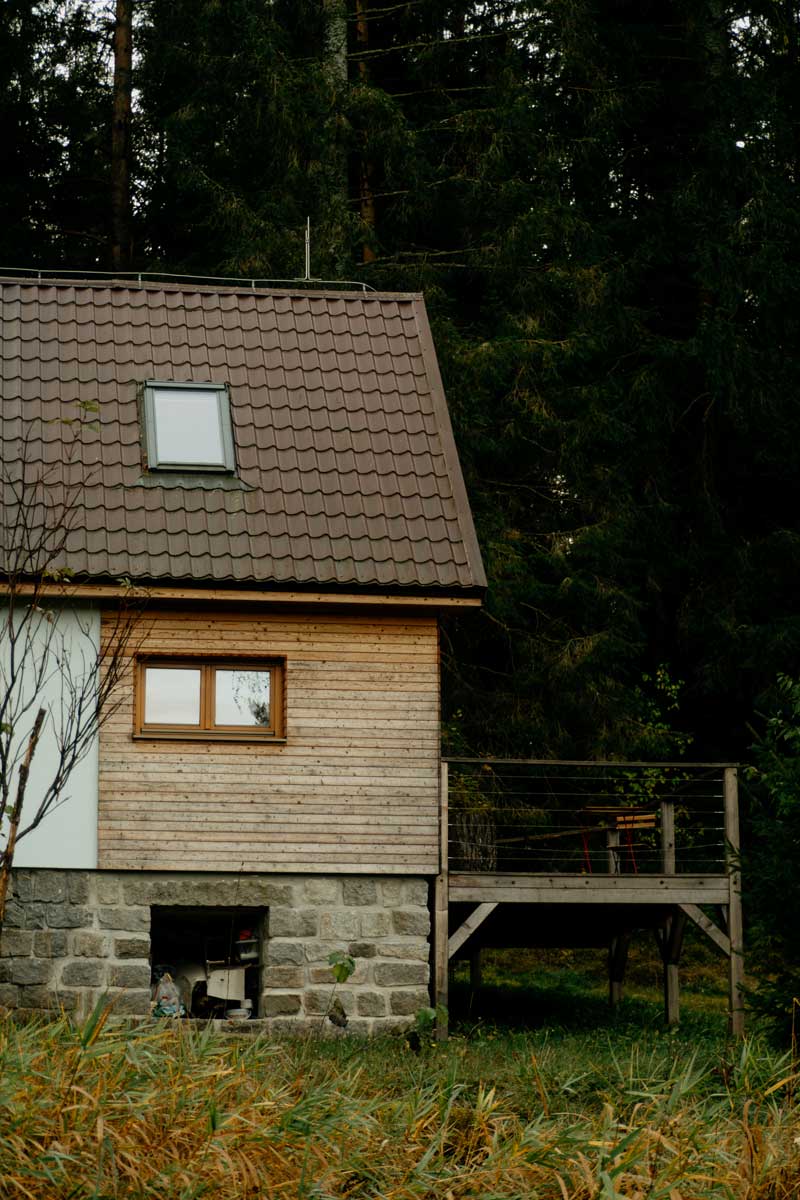 Dřevěná chata s terasou a výhledem do lesa