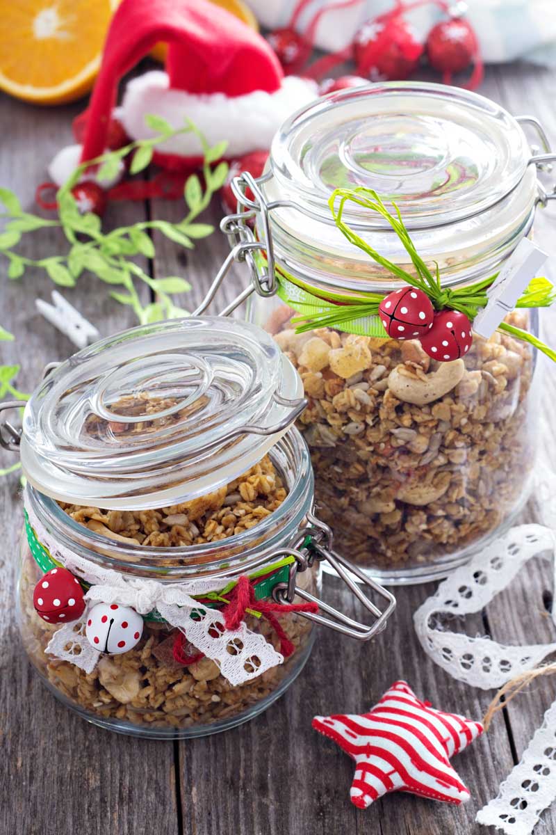 domaci granola Domácí granola ve sklenicích zdobených vánočními stužkami a dekoracemi, připravená jako jedlý dárek.