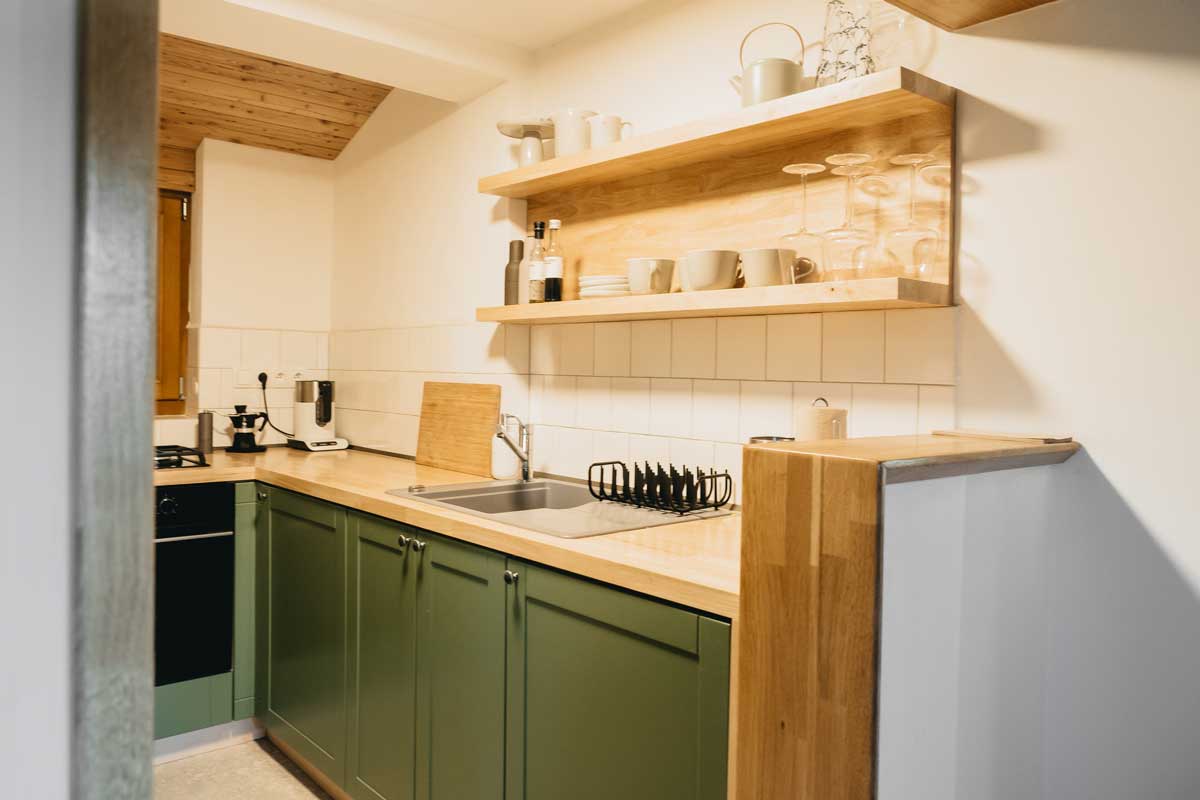 Funkční kuchyňský kout navržený s důrazem na praktičnost a dřevo.