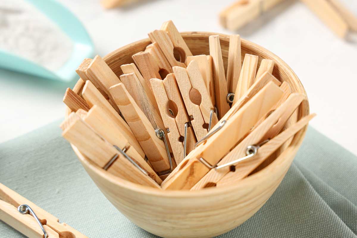 Miska plná dřevěných kolíčků na prádlo, vhodných jako pomůcka při zatloukání hřebíků.