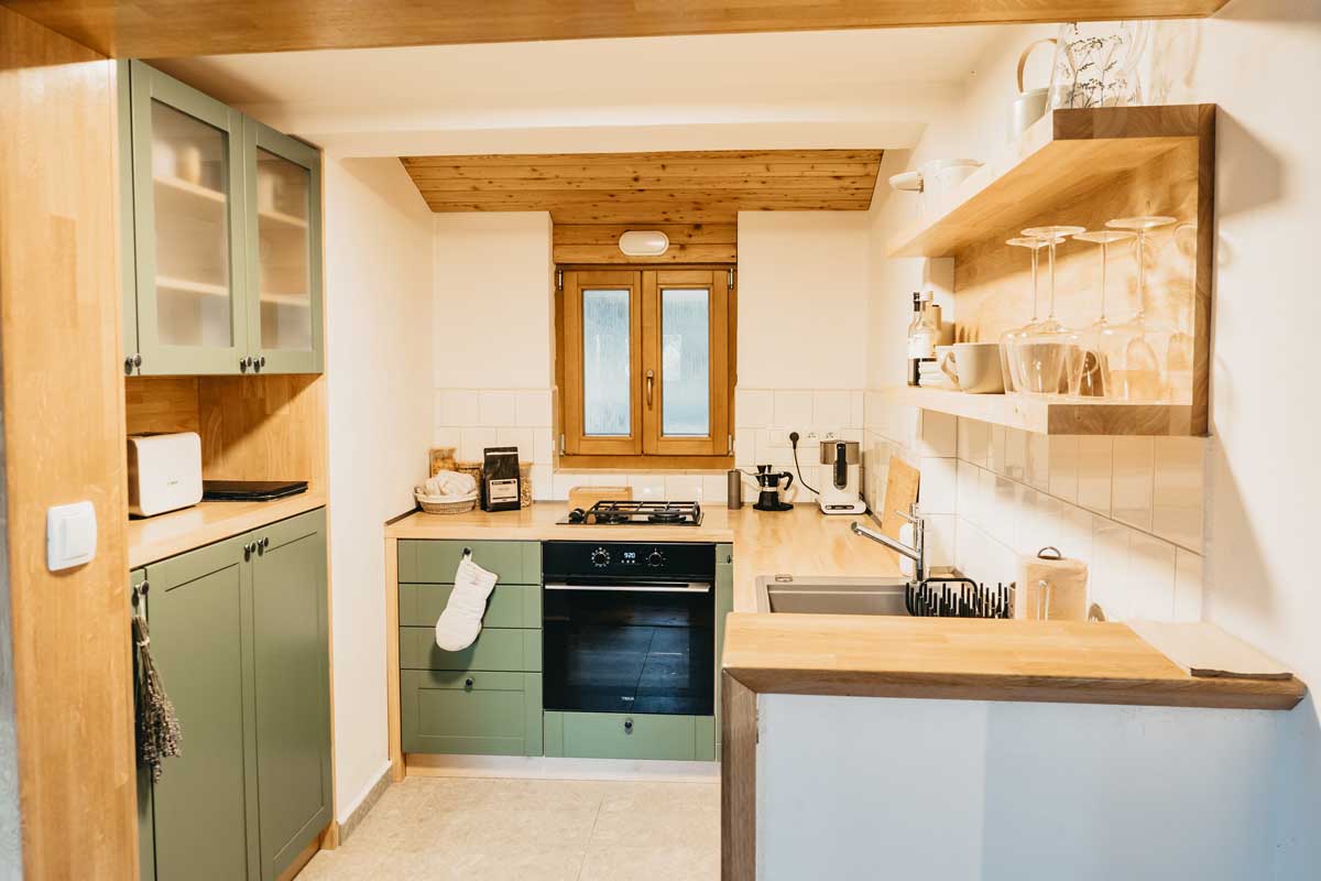 Plně vybavená kuchyně v příjemných tónech působí jemně a zároveň poskytuje vše, co na chatě člověk potřebuje. I dostatek odkládacího místa.