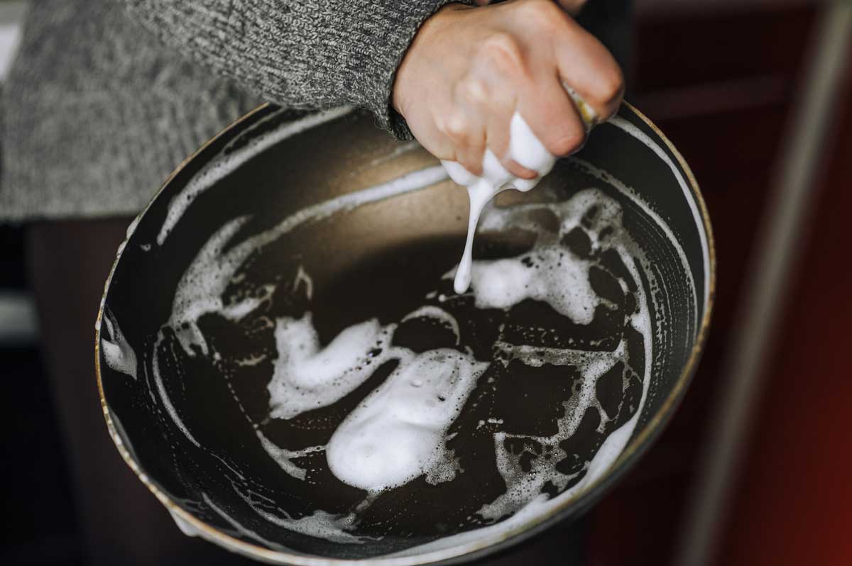 Mytí pánve po smažení ryby jako důležitý krok k odstranění přetrvávajícího zápachu v kuchyni