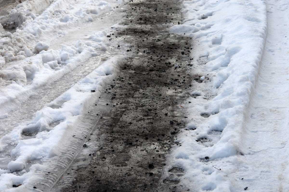 Zledovatělý povrch posypaný popelem z krbu