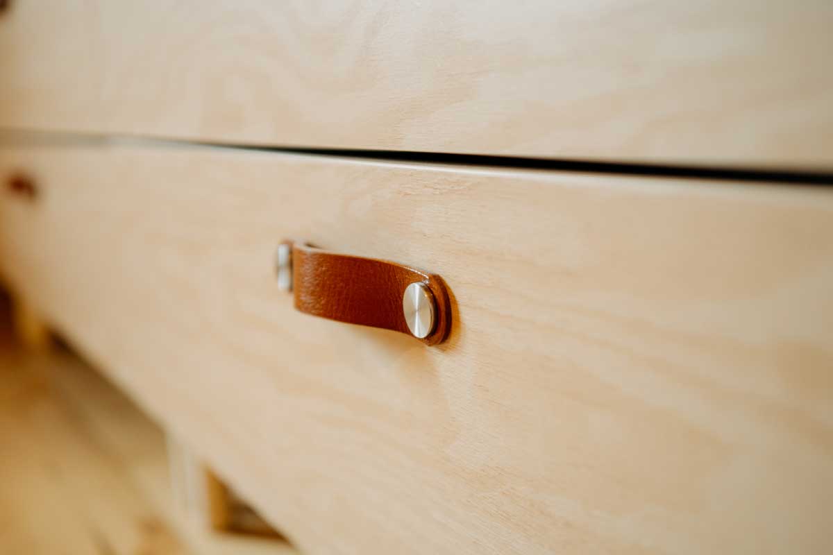 Drobné detaily, jako kožené úchytky, podtrhují poctivost a řemeslný charakter interiéru.