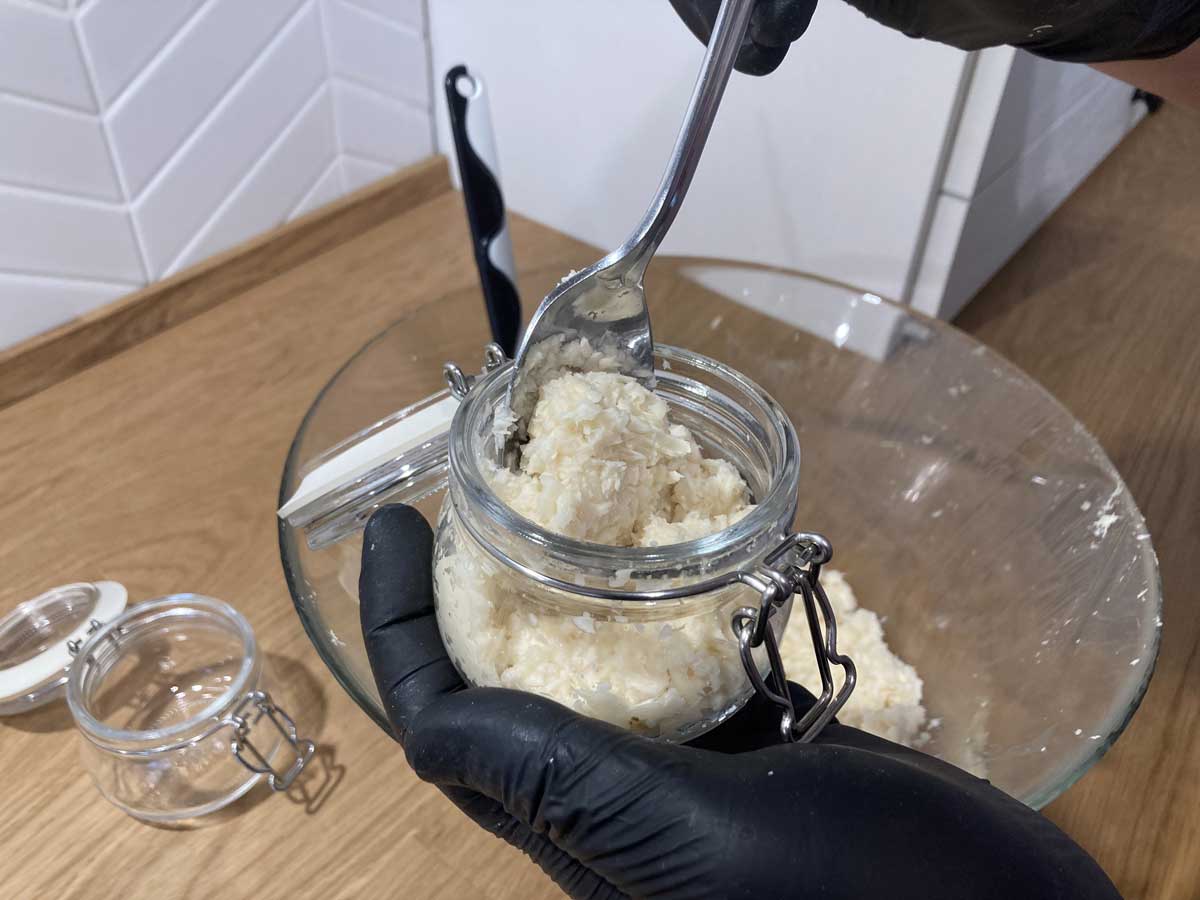 Plnění nastrouhaného křenu do sklenic určených k uchování v chladu.