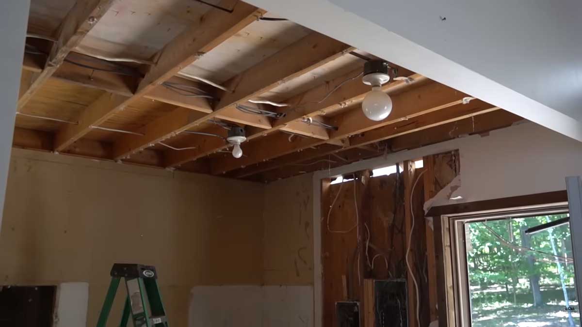 Odkrytý strop při rekonstrukci domu s viditelnými trámy a připravenými elektrickými rozvody