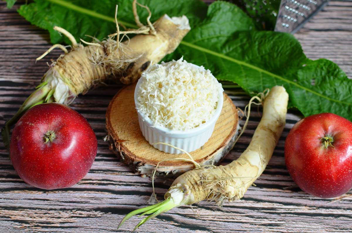 Nastrouhaný křen s jablkem připravený jako jemnější varianta tradiční křenové přílohy.