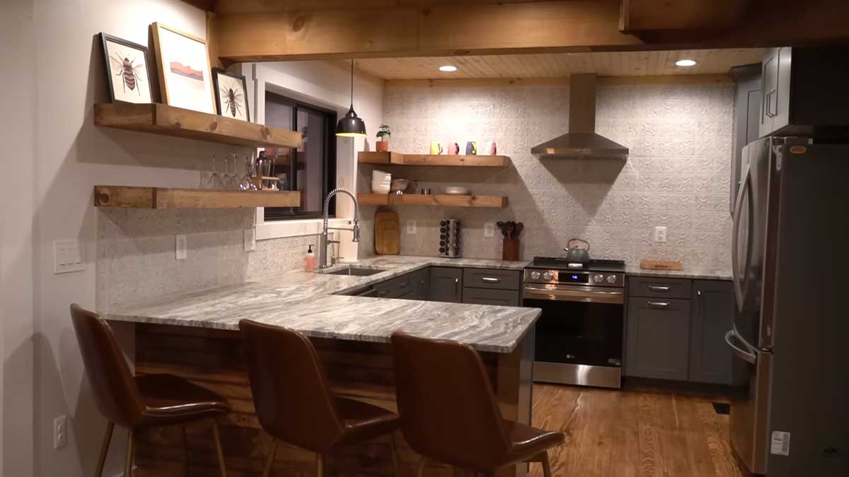 Nová kuchyně po rekonstrukci kombinuje přírodní dřevo moderní linku a praktické otevřené police.