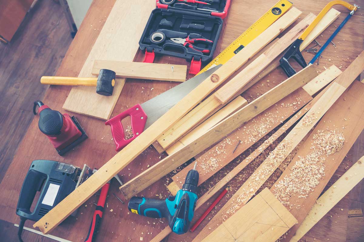 Základní truhlářské nářadí rozložené na pracovním stole