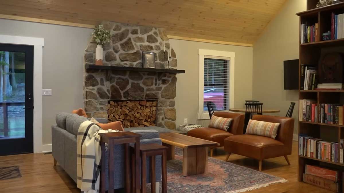 Obývací pokoj po rekonstrukci působí útulně díky krbu dřevu a promyšlenému uspořádání.