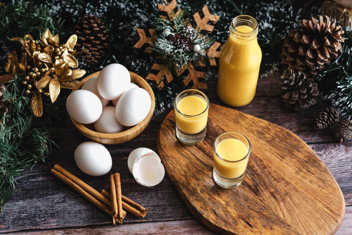 Domácí vaječný likér z vajec a mléka podávaný ve skleničkách v zimní atmosféře