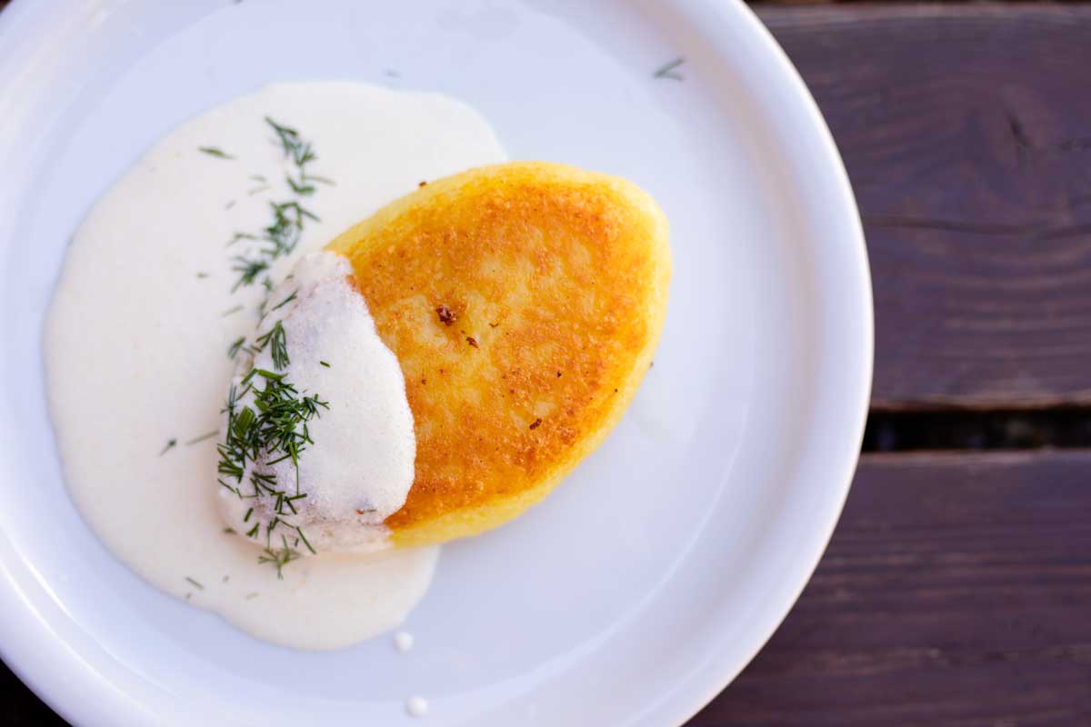 Tradiční litevské bramborové placky bulviniai blynai smažené dozlatova a servírované na talíři.