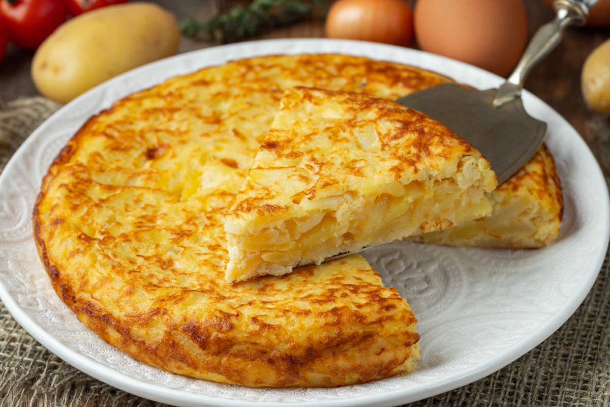 Galicijská tortilla de Betanzos z brambor a vajec s jemně tekutým středem podávaná nakrájená na klínky.