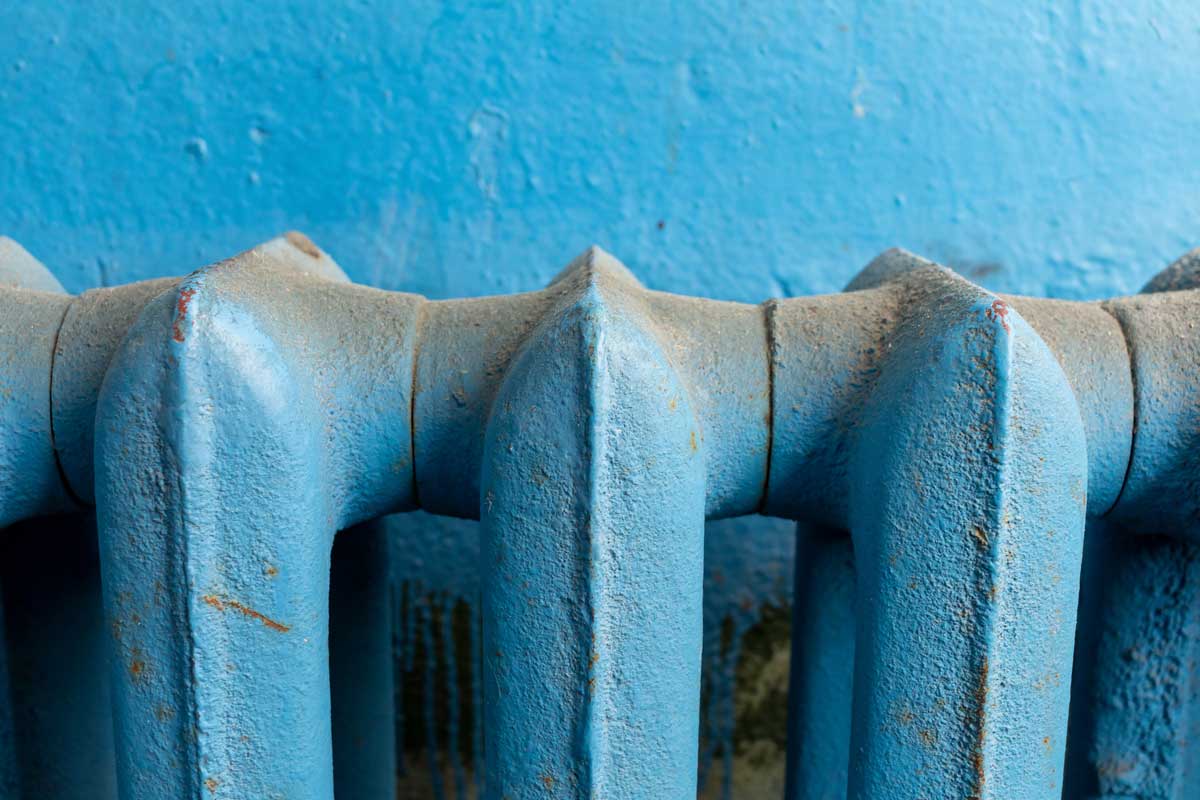 Radiátor zanesený prachem, který se při topení uvolňuje do vzduchu a zhoršuje kvalitu ovzduší v bytě