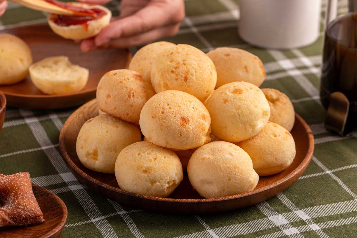 Brazilský sýrový chléb pão de queijo servírovaný v misce jako malé kulaté pečivo s měkkým sýrovým středem.